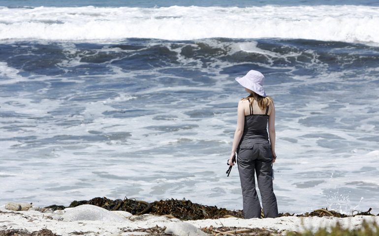 A woman looks out at the Pacific Ocean in Carmel, Calif., in 2008. (CNS/Gregory A. Shemitz)