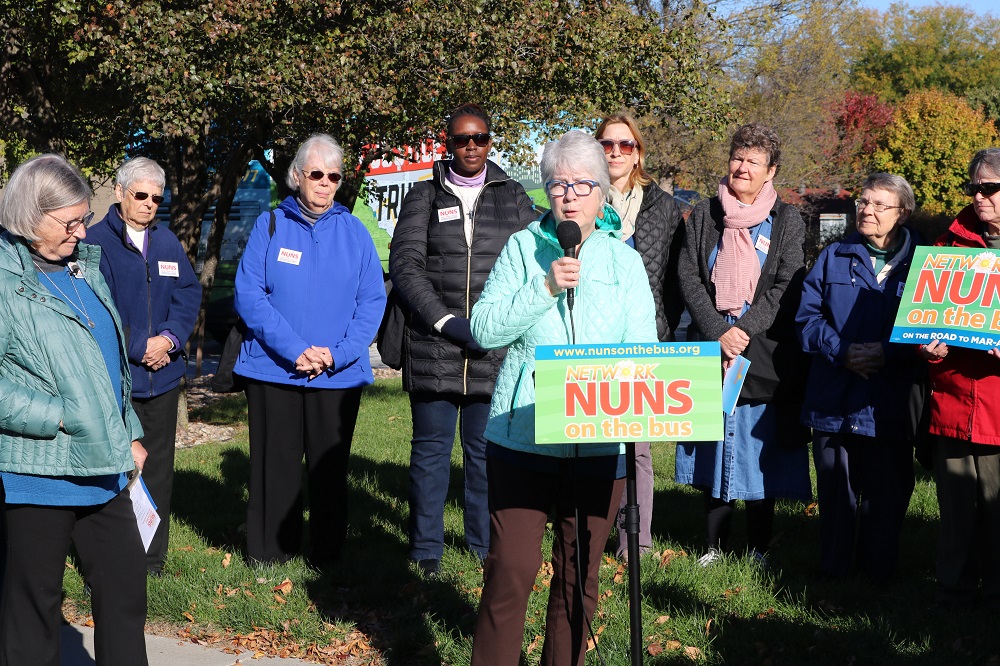 Julie Kalkowski of Financial Hope Collaborative speaks Oct. 16 at a Nuns on the Bus rally outside the office of U.S. Rep. Don Bacon in Omaha, Nebraska. (Network Lobby for Catholic Social Justice / Colleen Ross)