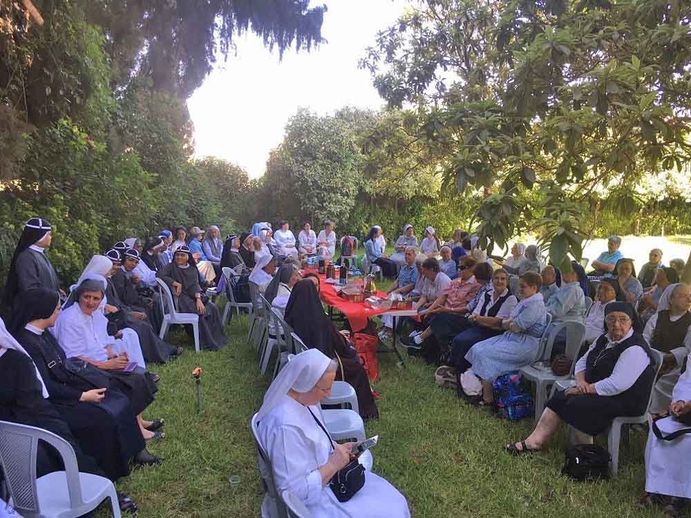 Sister members of the Union of Religious of the Holy Land sit at the garden of the Franciscans in Jericho while waiting for Abouna Mario to speak. (Natalia Liviero)