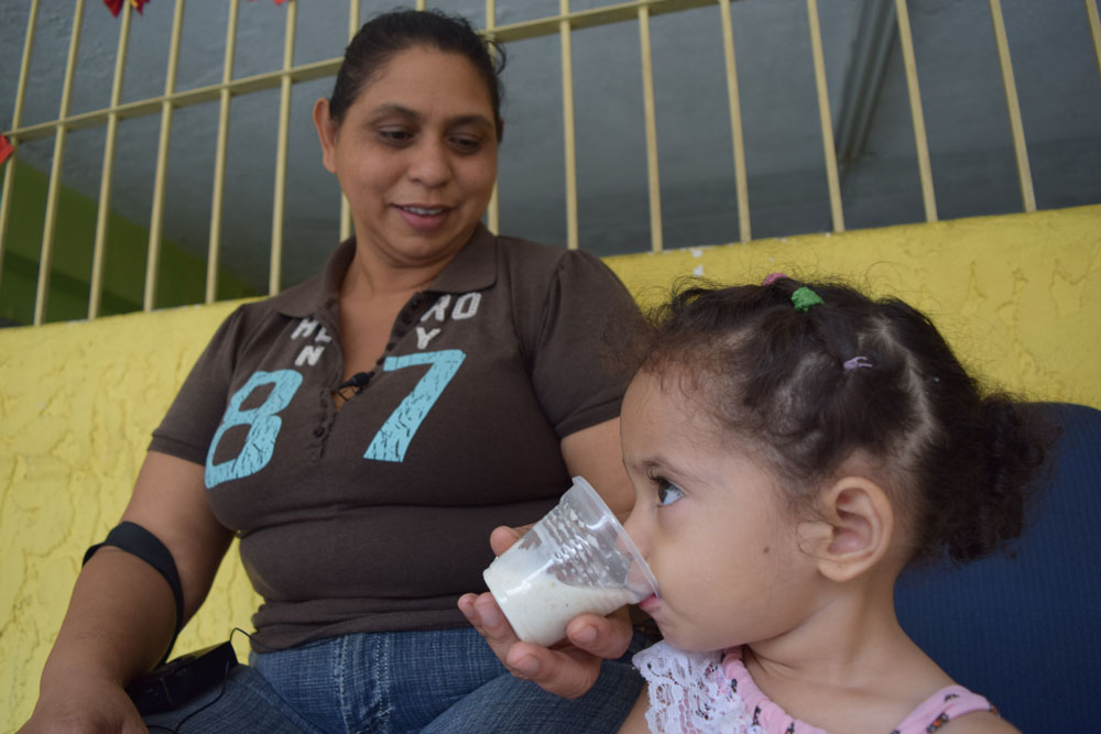 Yudelsi Avila watches as her daughter, Rebeca, eats oatmeal. Rebecca was once diagnosed as malnourished but has recovered thanks to the help of local Catholic organizations. (Cody Weddle)