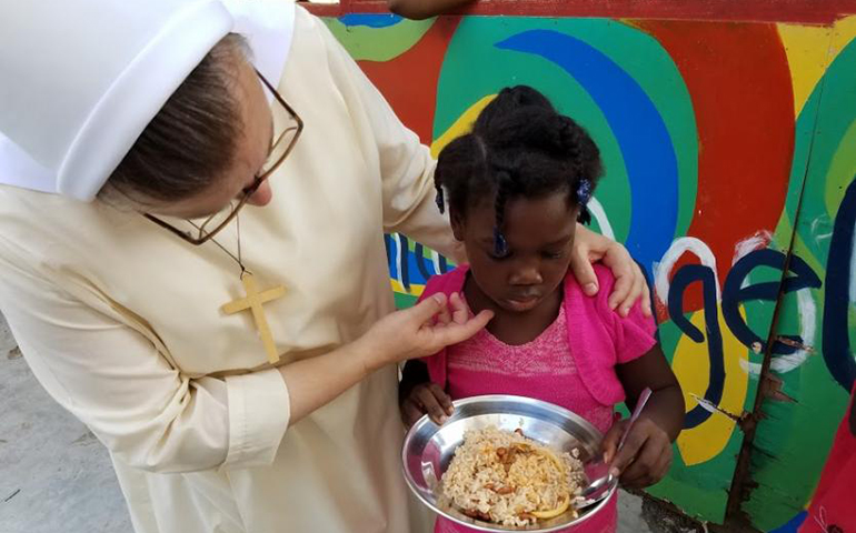 Felician Srs. Mary Inga Borko, left, and Marilyn Marie Minter, not shown, serve meals as part of a community-based after-school program for about 60 children in Jacmel. (GSR photo / Chris Herlinger)