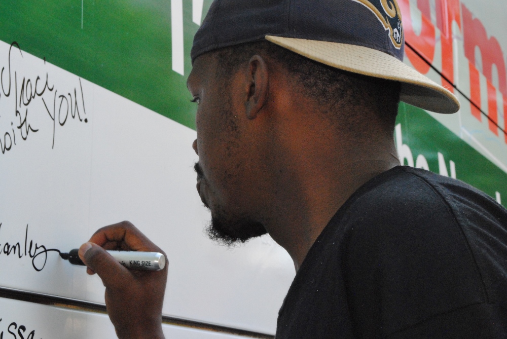 A man adds his name to the Nuns on the Bus bus in support of the sisters. (GSR photo / Dawn Cherie Araujo)