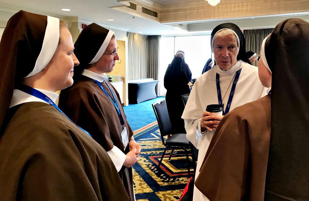 Three members of the Sister Servants of the Eternal Word, a new order that joined the Council of Major Superiors of Women Religious this year as an associate member, chat with Mother Mary Assumpta, in white, prioress general of the Dominican Sisters of Mary, Mother of the Eucharist, at the 2017 CMSWR annual assembly, held Oct. 12-15 in St. Louis. (GSR photo / Dawn Araujo-Hawkins)