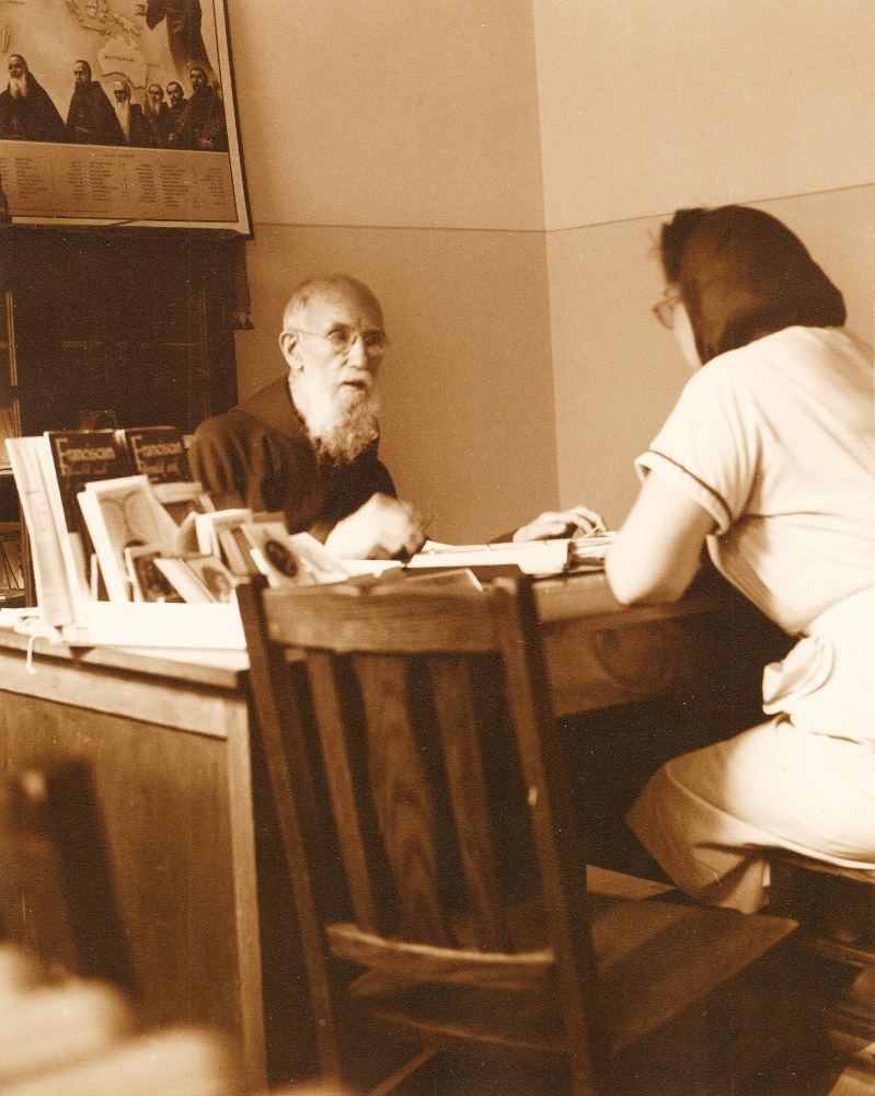 Fr. Solanus Casey talks to a woman in 1954. (CNS / The Michigan Catholic)