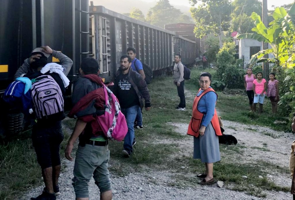 Franciscan Missionaries of Mary Sr. Carmen Balbuena is seen with migrants next to "La Bestia" in Mexico. (Courtesy of the Franciscan Missionaries of Mary)