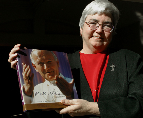 Mercy Sr. Mary Ann Walsh in 2003, holding a book she edited. (CNS / Bob Roller)