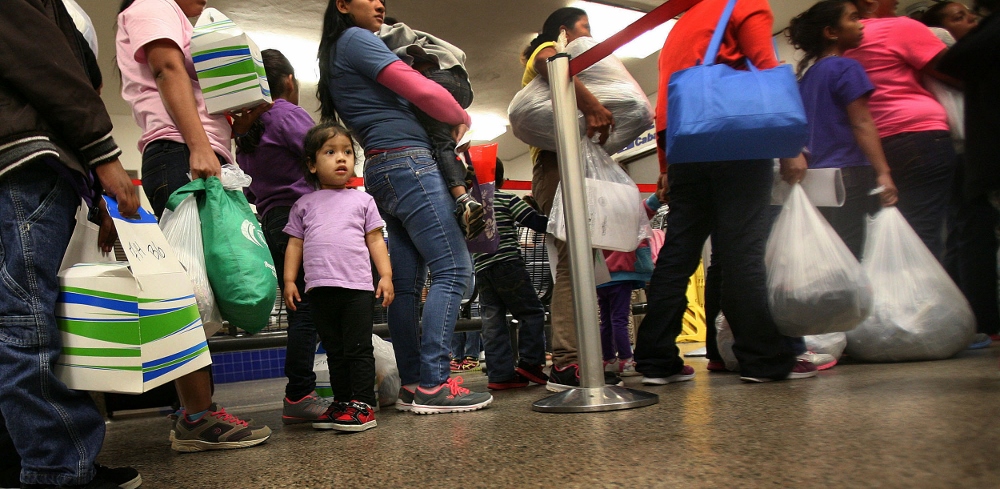 Genesis Pagoada, 2, of Honduras, stands in line with other immigrant families released from a detention center in Dilley, Texas, at the Greyhound Bus Station in San Antonio on July 14. In the last few weeks, the numbers of families released by ICE has been increasing significantly, overwhelming volunteers who greet them. (GSR photo / Nuri Vallbona)