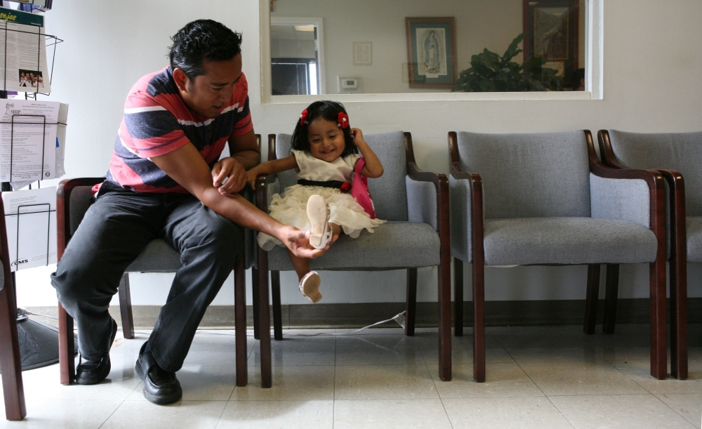 Fabian Martinez of Chiapas, Mexico, entertains his daughter, Nicole Martinez, 2, while they wait for his wife, Maresa Gutierrez who is consulting with an immigration attorney at Guadalupan Multicultural Services' La Casita in Birmingham, Alabama. The center, run by the Guadalupan Missionary Sisters of the Holy Spirit, provides social services, legal help and education to members of the community. (GSR photo / Nuri Vallbona)