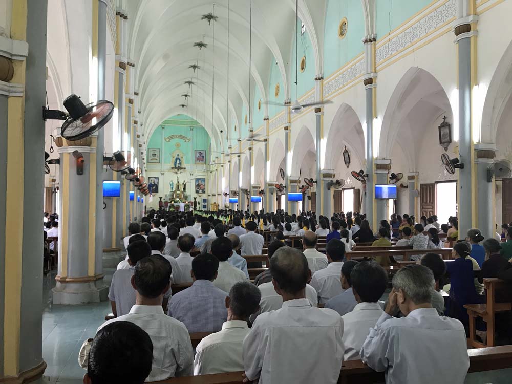 Catholics attend Mass at the cathedral nearby the Lovers of the Holy Cross of Vinh's motherhouse. The cathedral was rebuilt in 1979 after the old one was destroyed by US air attack in 1968. (Joachim Pham)