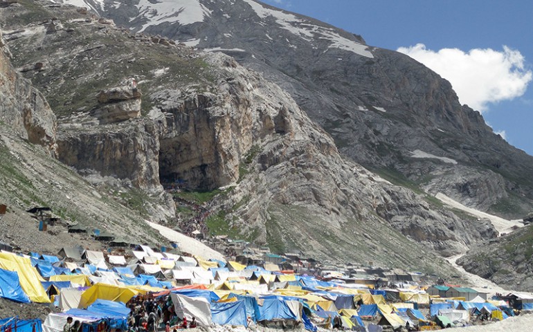 Tents are seen at the base of the imposing Amarnath Cave, which Hindu pilgrims walk to in the background. (Creative Commons/Hardik Buddhabhatti)