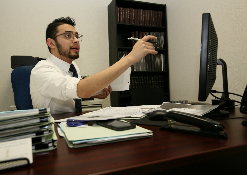 Legal assistant Enrique Chavira, a DACA recipient, helps gather information from other immigrants in the law office of Tania Rosamond in Austin, Texas. Although his immigration status may change after Donald Trump takes office, he vowed to stay optimistic and keep working for clients. (GSR photo / Nuri Vallbona)