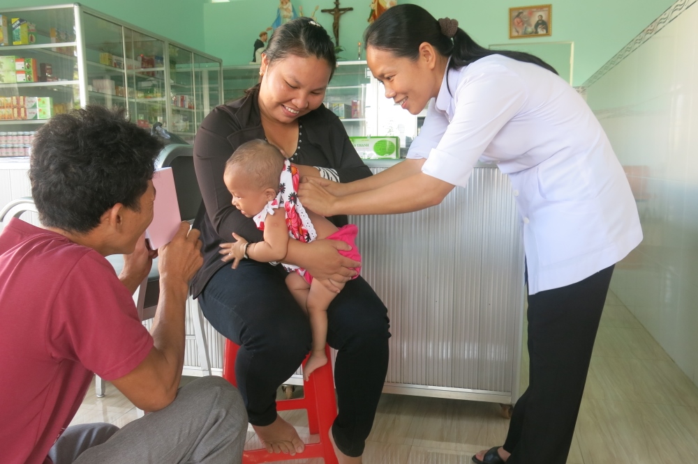 Dominican Sr. Mary Doan Thi Thuy An treats a baby with traditional methods at the clinic. (GSR photo / Joachim Pham)