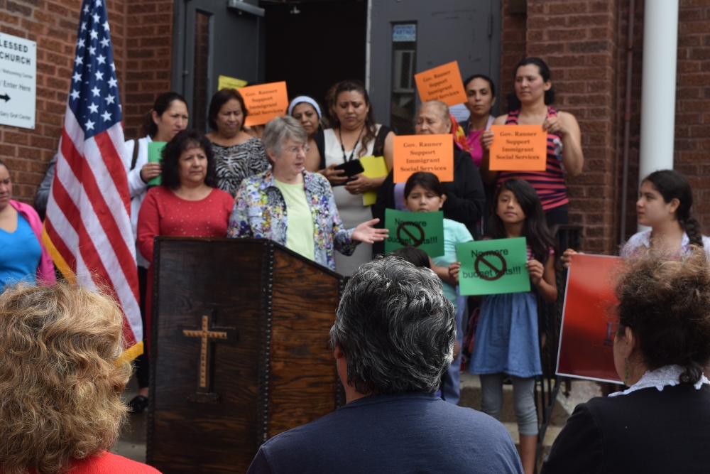Outside her office, Sr. Kathleen Long, at the podium, calls for Illinois Gov. Bruce Rauner to pass the budget for Immigrant Service Line Items in 2015. Rauner did not support any immigrant budget items, Long said. (Provided photo)