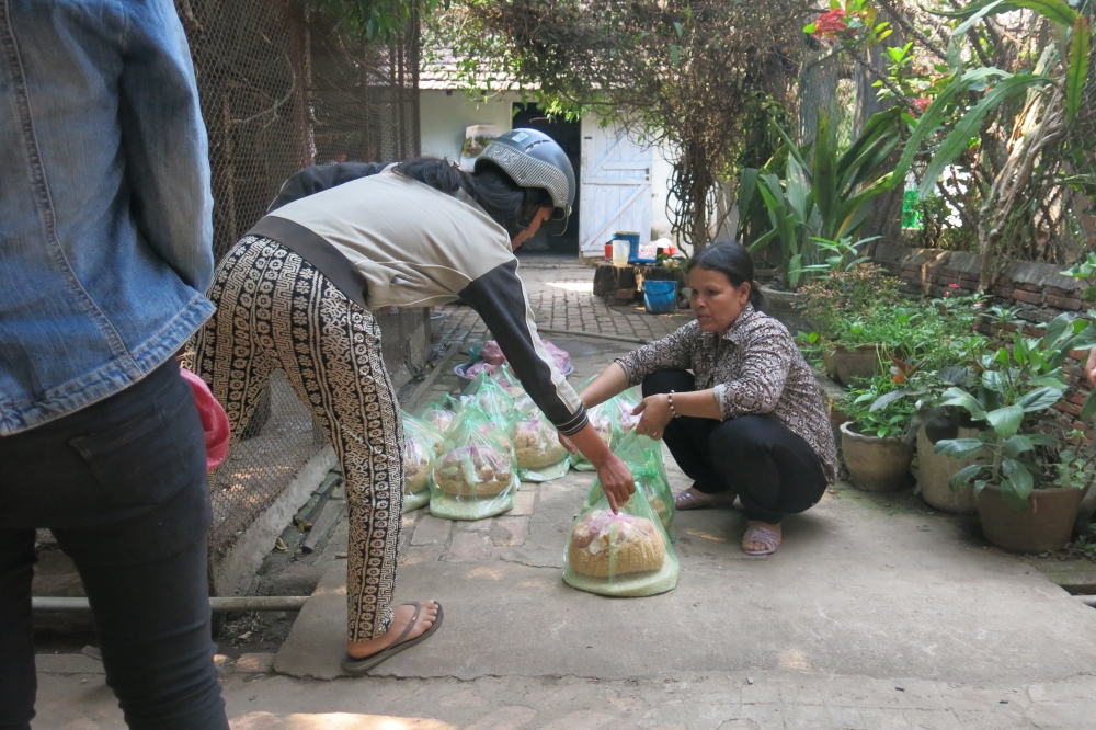 Ba Na ethnic volunteer Binh distributes rice, instant noodles and pork to ethnic villagers at the convent. (GSR photo / Joachim Pham)