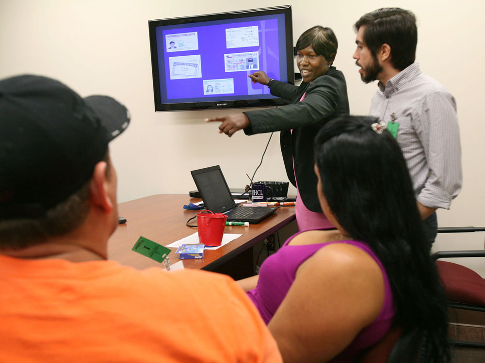 Margaret Ayot, program supervisor for the Refugee Resettlement Program of Catholic Charities in Houston, answers questions from a newly arrived group of Cuban immigrants during a cultural orientation program in September. Ayot provides the orientation sessions to inform refugees about their rights, U.S. laws and general customs. On the right is interpreter Noel Rodriguez. (GSR photo / Nuri Vallbona)