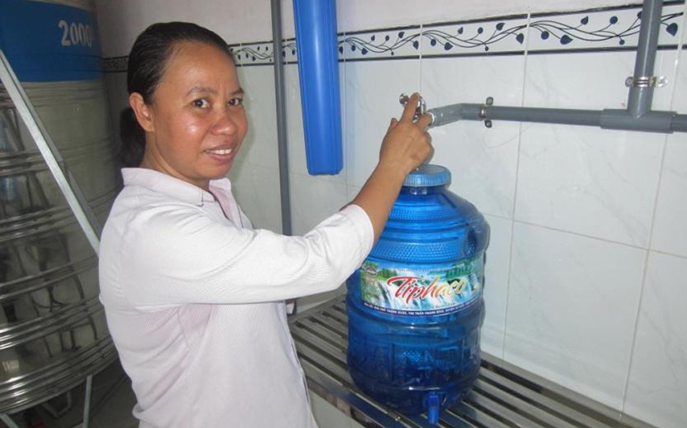Dominican Sr. Anna Tran Thi Thanh Thu bottles water treated with ultraviolet light for clients at her convent in Binh Phuoc Province. (GSR/Joachim Pham)