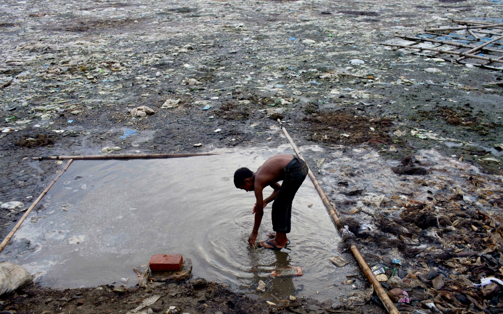 A boy washes himself in a polluted pond in the Hazaribagh area of Dhaka, Bangladesh, in 2014. The Hazaribagh area, widely known for its tannery industry, is considered one of the most polluted places on earth. (Newscom / ZUMA Press / Probal Rashid)