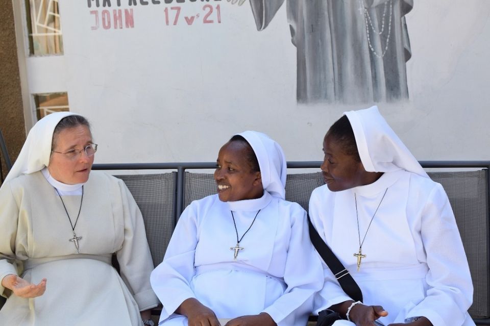 Sr. Eva Korbut, left, superior general of the Missionary Sisters of the Holy Family, from Poland listens to her sisters share their work-related experiences in Lusaka, Zambia, during her canonical visit in 2019. (Courtesy of Lilian Atieno)