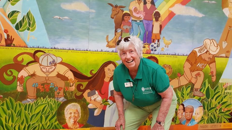 Sr. Ann Kendrick poses with a mural inside Hope CommUnity Center in Apopka, Florida. (GSR photo/Gail DeGeorge)