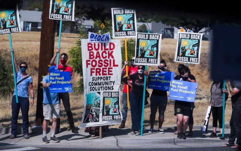 Protesters against the continued use of fossil fuel hold signs along a road in Mather, California, as President Joe Biden visits the area in September. (CNS/Reuters/Leah Mills)