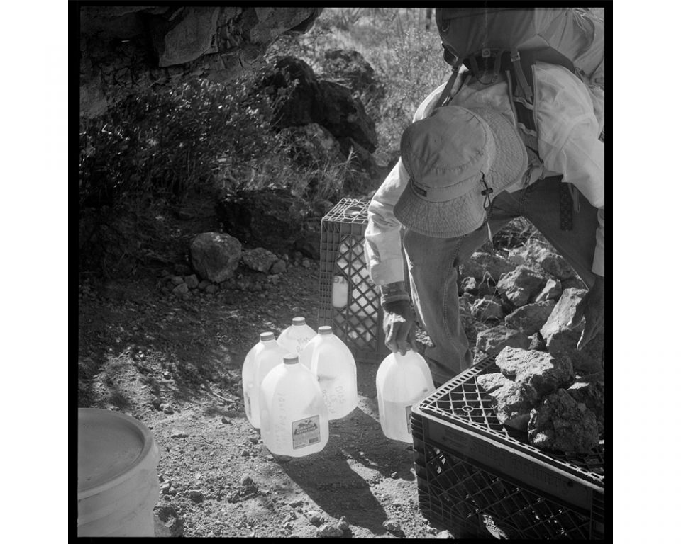 A volunteer takes the empty jugs back, and leaves a half-full one just in case. (Lisa Elmaleh)