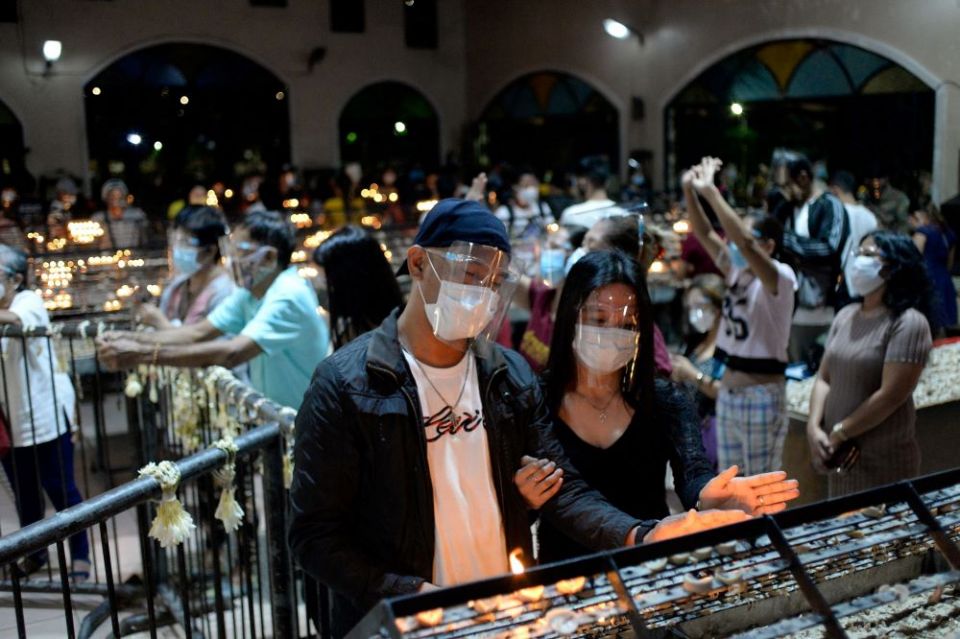 People wearing protective masks and face shields light candles after the first novena Masses for Simbang Gabi at the National Shrine of Our Mother of Perpetual Help in Manila, Philippines, Dec. 16, 2020. (CNS photo/Lisa Marie David, Reuters)