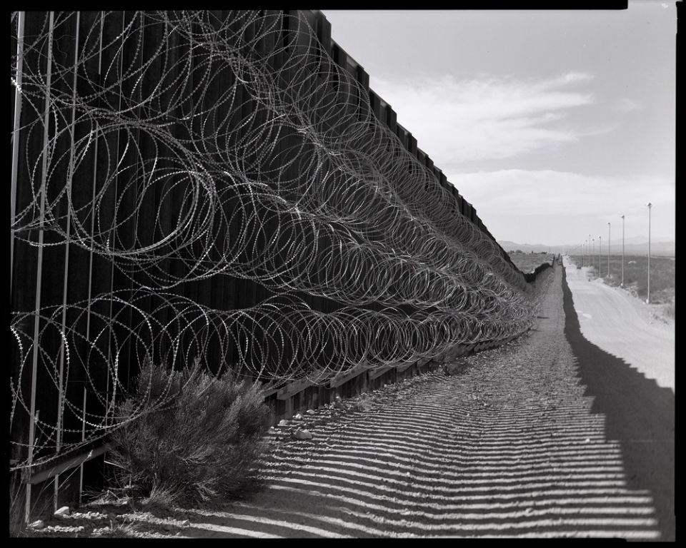 The border wall in Douglas, Arizona, in October 2020. The barbed wire is a typical feature on parts of the wall that border two cities, such as this one straddling Douglas and Agua Prieta, Mexico. (© Lisa Elmaleh) The border wall in Douglas, Arizona, in October 2020. The barbed wire is a typical feature on parts of the wall that border two cities, such as this one straddling Douglas and Agua Prieta, Mexico. (© Lisa Elmaleh)