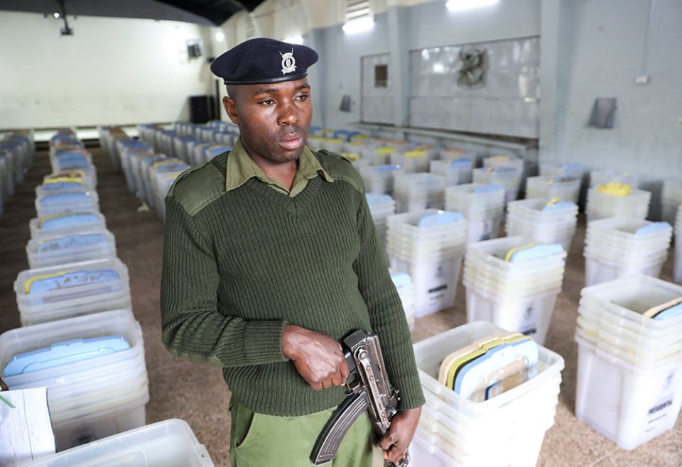 A Kenyan police officer stands guard over ballot boxes and election material at a polling station in Nairobi Aug. 4. Following William Ruto's victory, parts of Kenya witnessed violent protests. (CNS/Reuters/Baz Ratner)