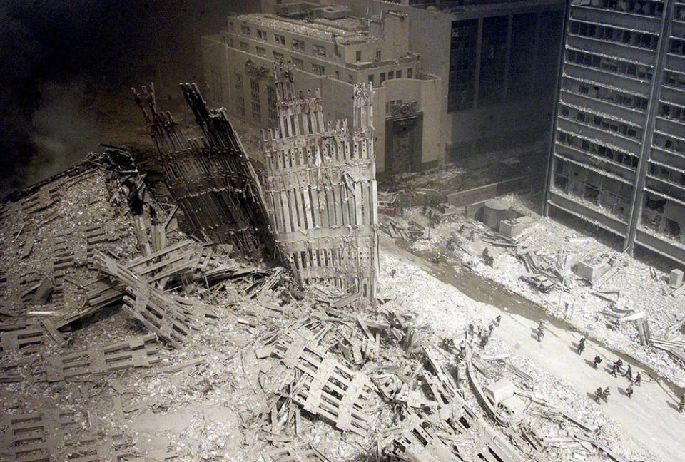Firefighters walk amid rubble near the base of the destroyed south tower of the World Trade Center on Sept. 11, 2001. (CNS/Reuters)
