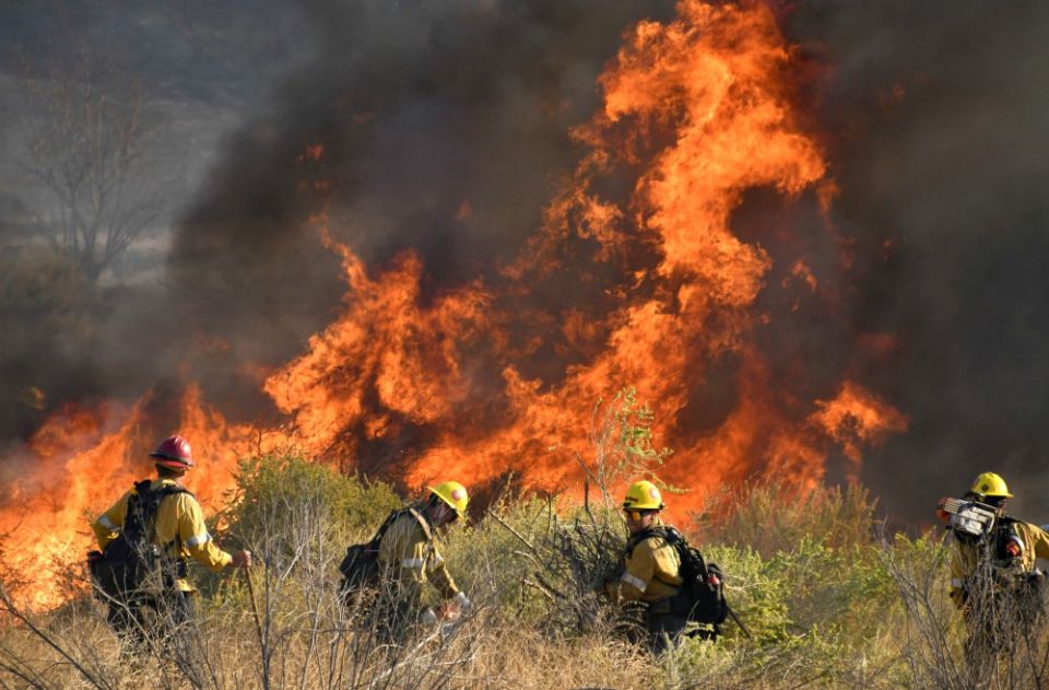 Firefighters battle a wind-driven wildfire Oct. 25 in Canyon Country near Los Angeles. (CNS/Reuters/Gene Blevins)
