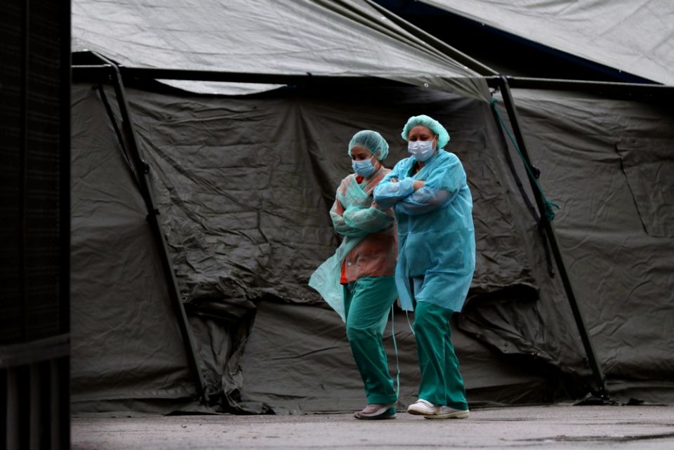 Medical staff wearing protective face masks and suits walk past a tent at Madrid's Gregorio Maranon Hospital April 1, amid the COVID-19 pandemic. (CNS / Reuters / Susana Vera)