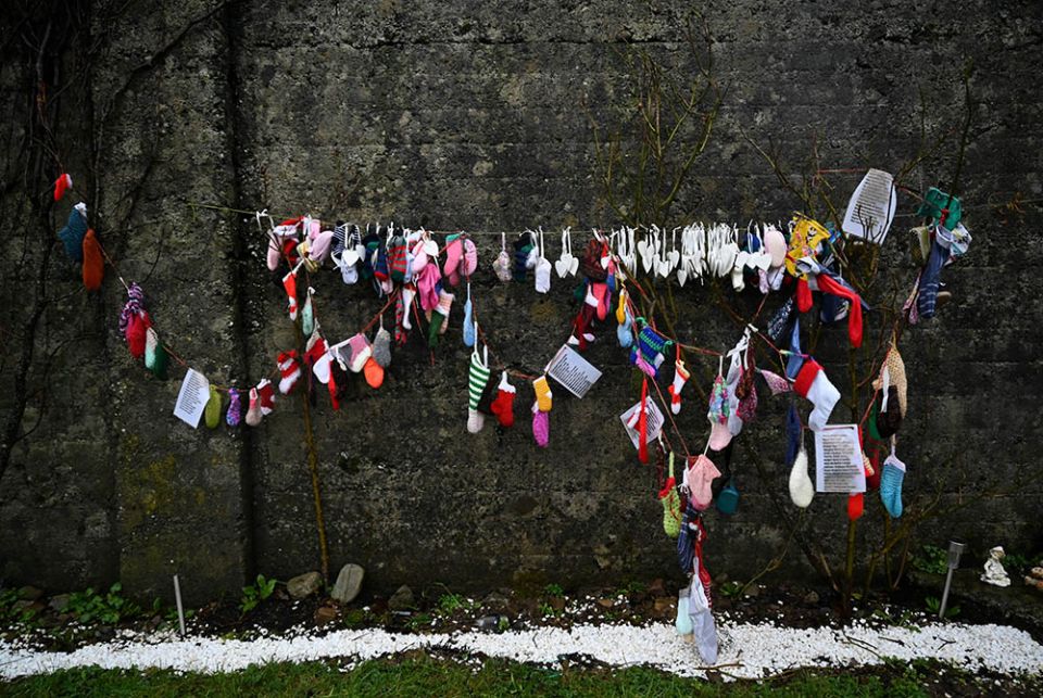 Baby clothing and other items hang from a wall at a cemetery in Tuam, Ireland, where the bodies of nearly 800 infants were uncovered at the site of a former Catholic home for unmarried mothers and their children. The photo was taken Jan. 12, the day a com