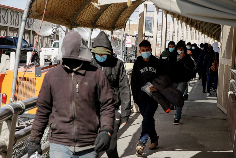 Migrants deported from the United States cross the Paso del Norte International Bridge in Ciudad Juarez, Mexico, on Jan. 25. On Jan. 20, U.S. President Joe Biden revoked a 2017 executive order authorizing massive expansion of immigration enforcement in th