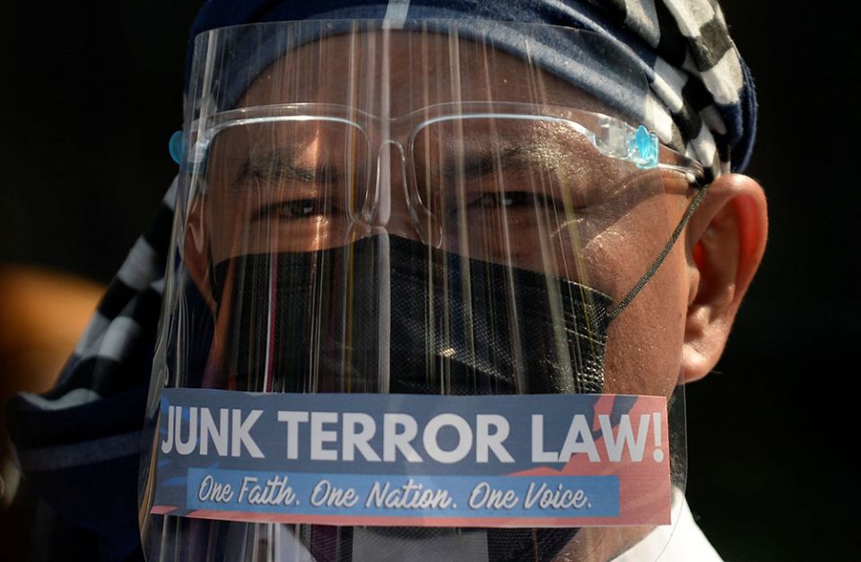 A priest wears a protective mask and face shield during a Feb. 2 protest outside a church in Manila, Philippines, before the start of the hearing of oral arguments on the anti-terrorism law. (CNS/Reuters/Lisa Marie David)