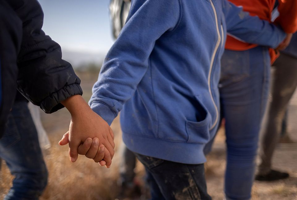 Unaccompanied minors from Central America seeking asylum in the United States hold hands March 12 as they await transport in Penitas, Texas, after crossing the Rio Grande. (CNS/Reuters/Adrees Latif)