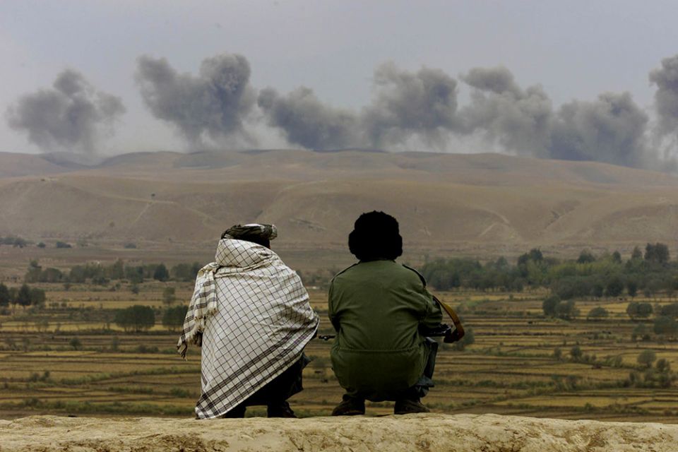 Two Northern Alliance soldiers near the village of Ai-Khanum in northern Afghanistan watch dust and smoke rise after explosions at Taliban positions Nov. 1, 2001. (CNS/Reuters/Vasily Fedosenko) Two Northern Alliance soldiers near the village of Ai-Khanum in northern Afghanistan watch dust and smoke rise after explosions at Taliban positions Nov. 1, 2001. (CNS/Reuters/Vasily Fedosenko)