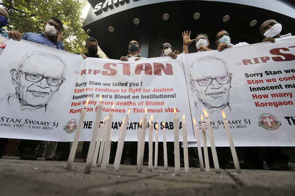 People hold a banner during a July 6 prayer service for Jesuit Fr. Stan Swamy in Mumbai, India, the day after he died at a hospital. (CNS/Reuters/Francis Mascarenhas)