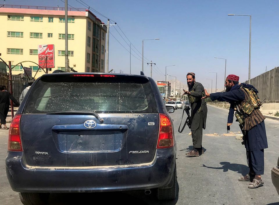 Members of Taliban forces check a vehicle on a street in Kabul, Afghanistan, on Aug. 16. (CNS/Reuters)