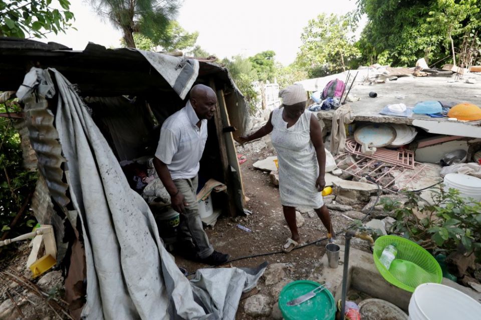 Sisters in Haiti are doing their best to continue their ministry and respond to emergency needs after the Aug. 14 earthquake. Here, Manithe Simon and his wife, Wisner Desrosier, walk through their collapsed home on Aug. 22. (CNS/Reuters/Henry Romero)