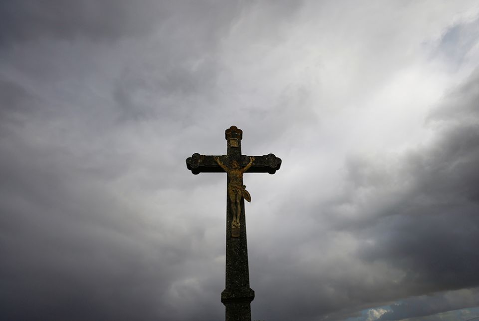 A cross is silhouetted outside a Catholic church Oct. 5 near Nantes, France. (CNS/Reuters/Stephane Mahe)