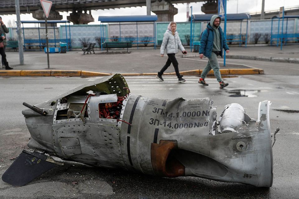 People in Kyiv, Ukraine, walk past the remains of a missile at a bus terminal March 4, as Russia's invasion of Ukraine continues. (CNS/Reuters/Valentyn Ogirenko)