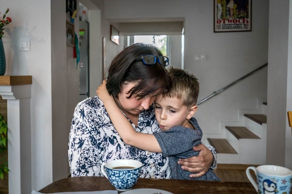 Ukrainian refugee Svetlana Starovytska comforts her son, Stanislav, 5, at the home of Olga and Mariusz Sulkowski in Otwock, Poland, on May 21. (CNS/Lisa Johnston)