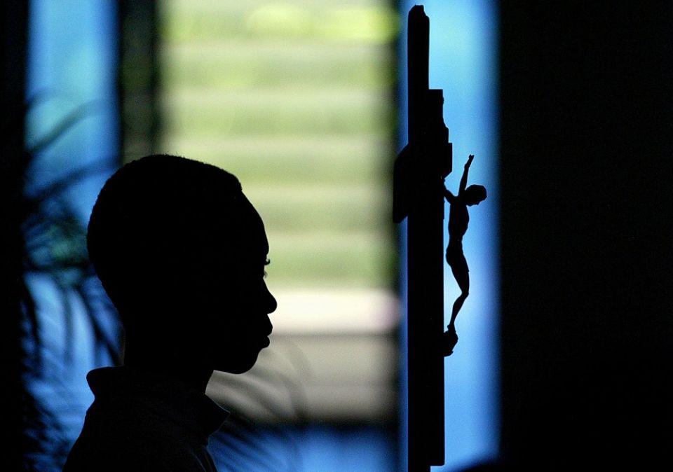 An altar server is pictured in a file photo holding a crucifix during Mass at a church in Port-au-Prince, Haiti.