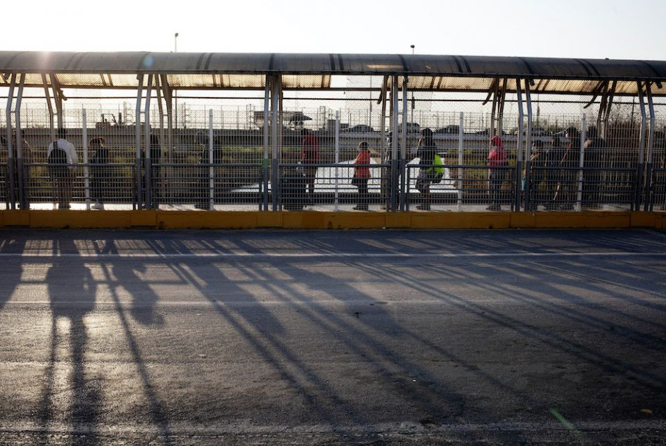 People authorized to cross the U.S.-Mexico border line up on the U.S. side of the McAllen-Hidalgo-Reynosa International Bridge early in the morning of March 22 in McAllen, Texas. (Nuri Vallbona)