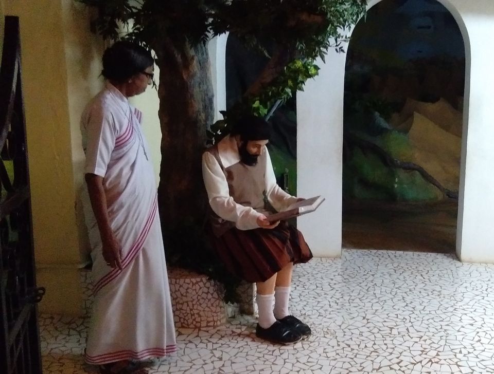 Sr. Judith Meckado of the Franciscan Missionaries of Christ the King looks at the seated statue of St. Francis Xavier in the show "A Pilgrimage of the Heart" at the Basilica of Bom Jesus in Old Goa, western India. (Lissy Maruthanakuzhy)