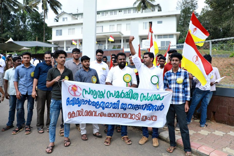 Members of the Mananthavady diocesan unit of the Kerala Catholic Youth Movement display a banner pledging support to Catholic religious life at the Pastoral Centre of Dwaraka parish. (Saji Thomas)