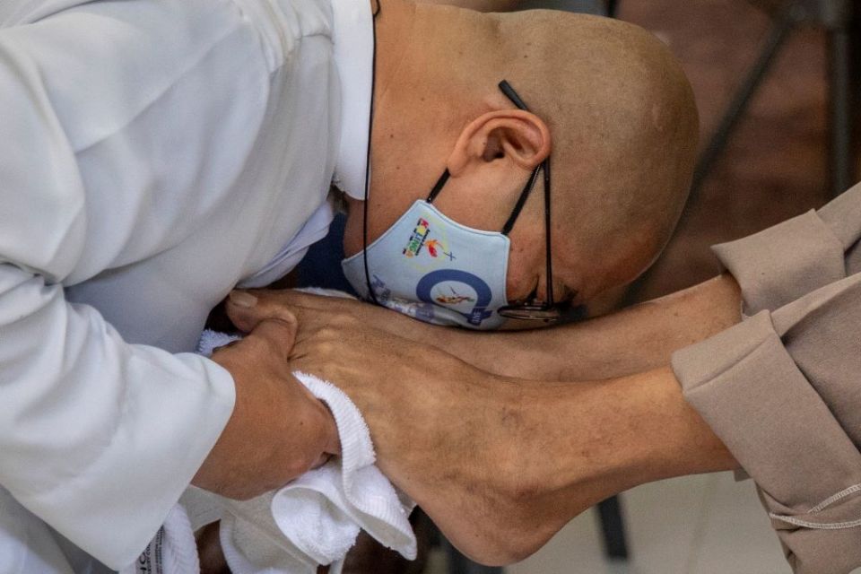 Fr. Flavie Villanueva, a member of the Society of the Divine Word, kisses the feet of a homeless man after washing them Holy Thursday in Manila, Philippines, April 1, 2021. (CNS/Reuters/Eloisa Lopez)