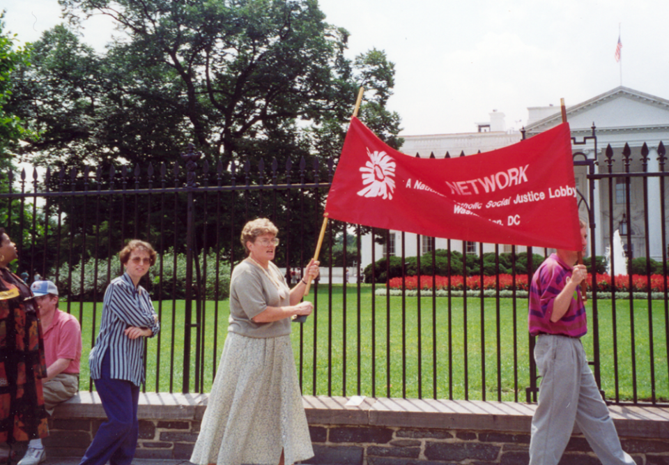 Mercy Sr. Kathy Thornton carries a Network banner in front of the White House in the 1990s. Thornton was executive director of Network from 1992 to 2003. (Courtesy of Network Lobby for Catholic Social Justice)
