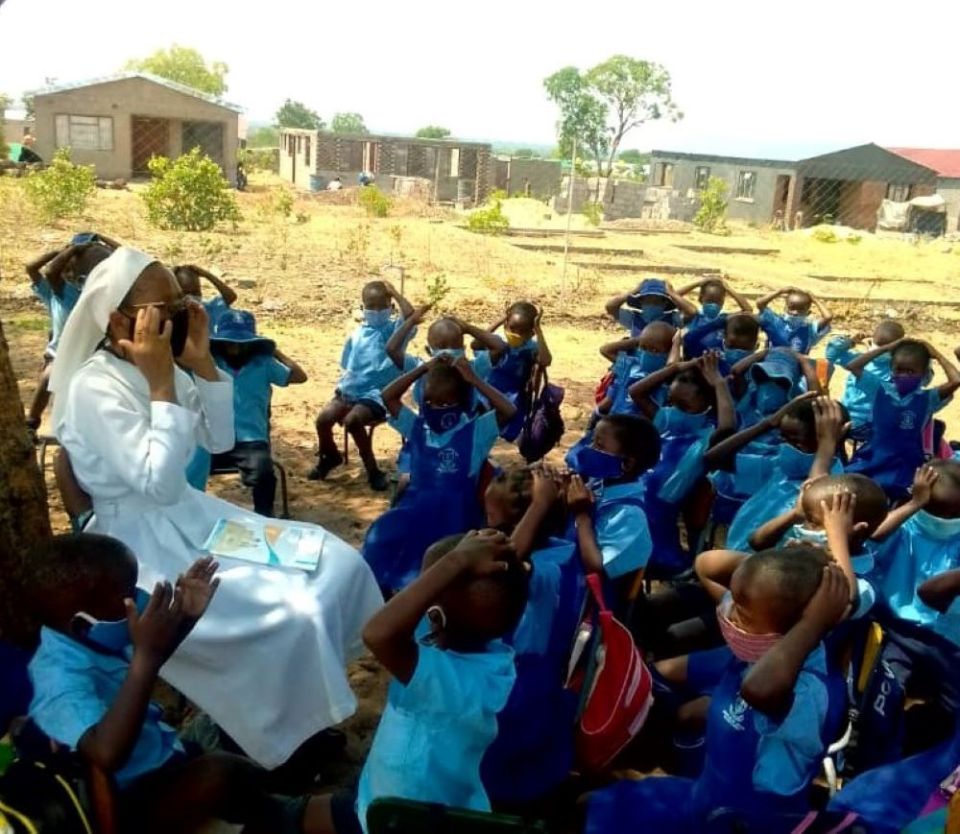 La Hna. Praxedis Nyathi habla con estudiantes en el programa de desarrollo de la primera infancia que dirige su congregación.  Las hermanas comenzaron las escuelas en Lupane en respuesta al requisito de Zimbabue de que los niños estén preparados para ingresar a la escuela primaria.