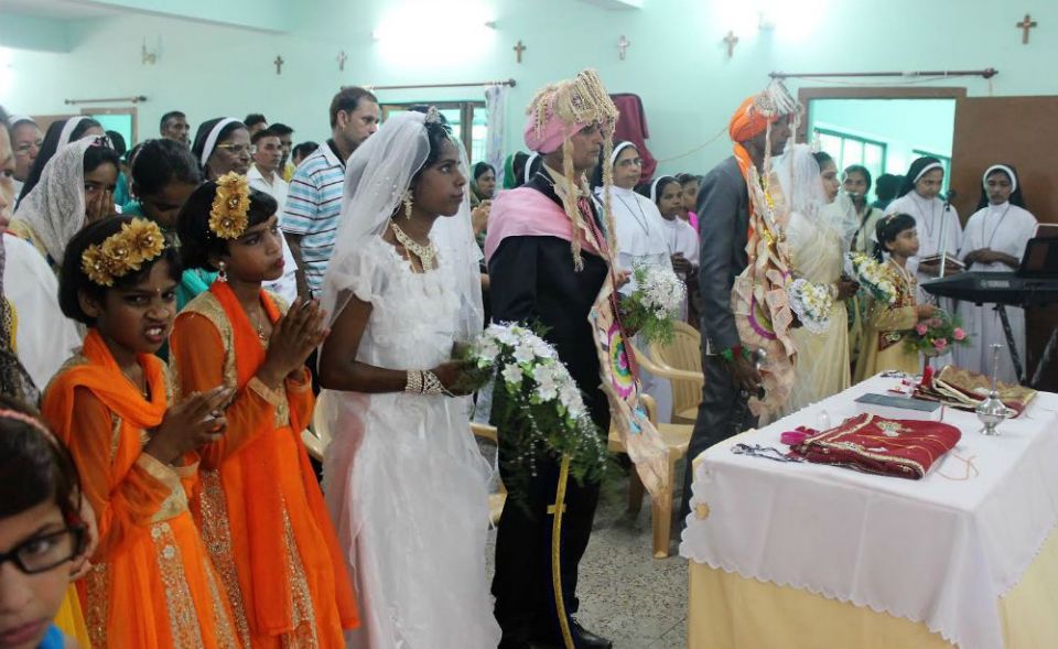 A double marriage ceremony of Sanjoepuram girls Rinky (with John), at left, and Beena (with Thomas) is officiated by Archbishop Kuriakose Bharanikulangara in 2017. (Jose Kavi)